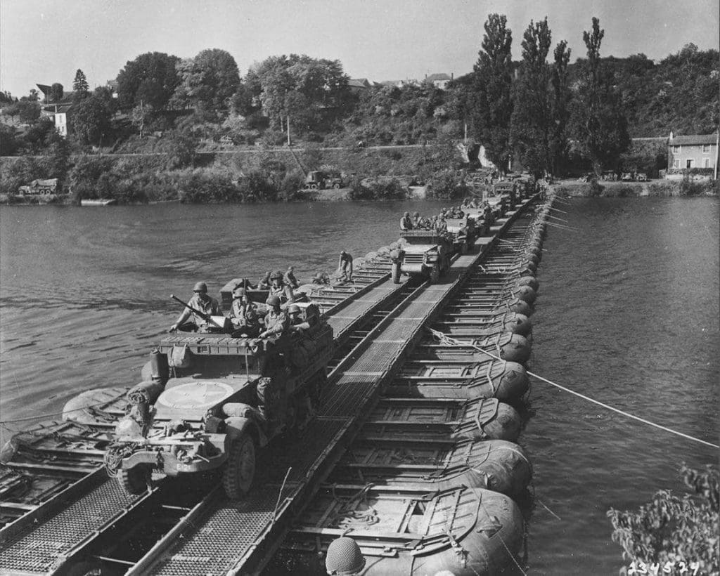 Columna de semi-orugas M-3A1 pertenecientes al US Army cruzan el río Sena por un puente hecho pontones. Francia, 1944. Imagen: US Army.